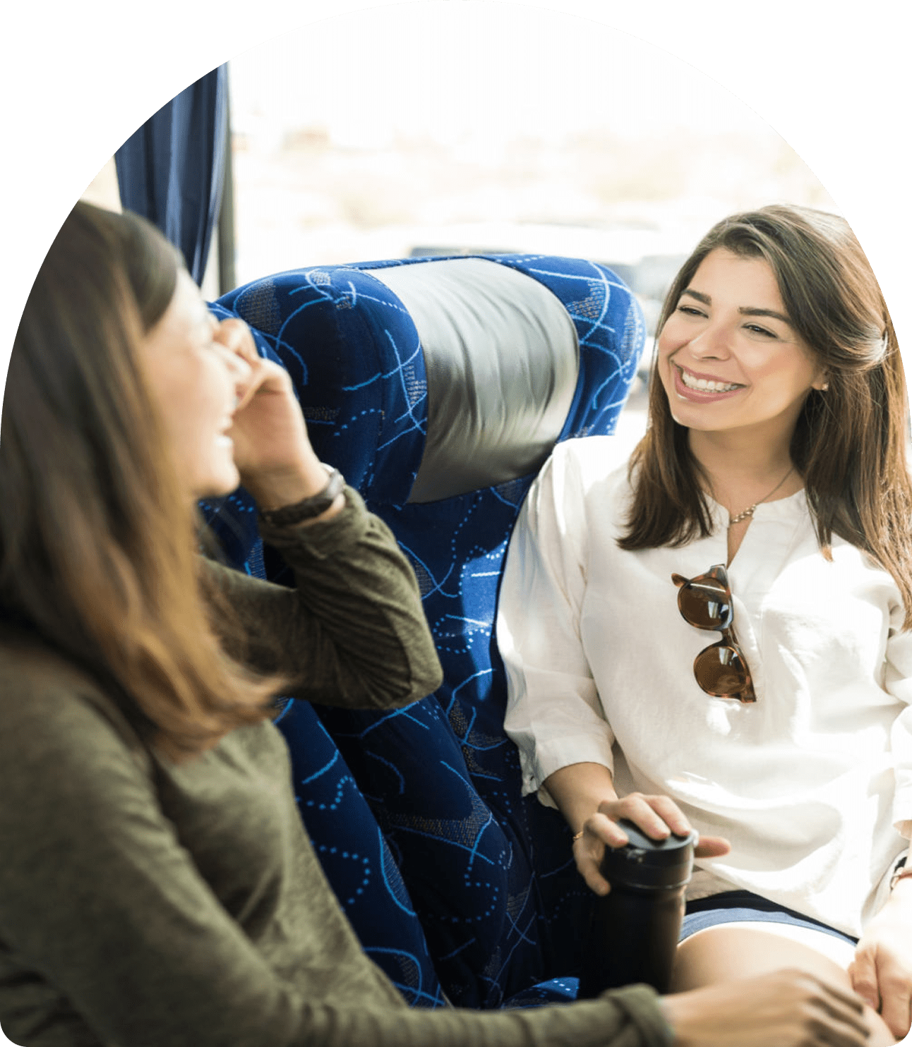 Women talking and smiling on a bus.